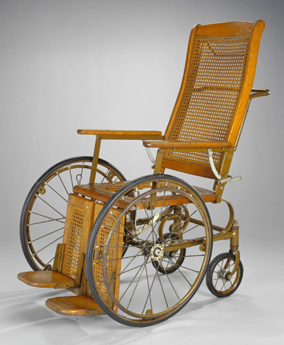 A wood-framed and wicker-backed wheelchair